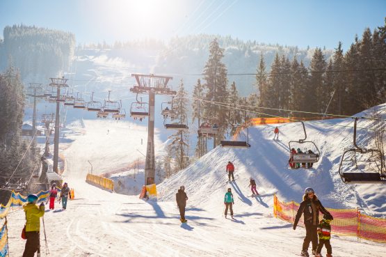 skiers-ski-lift-riding-up-ski-resort (1) 1